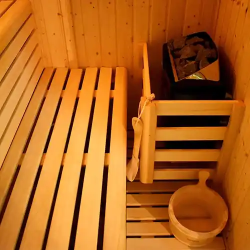 interior de sauna con caldero y piedras de calor.